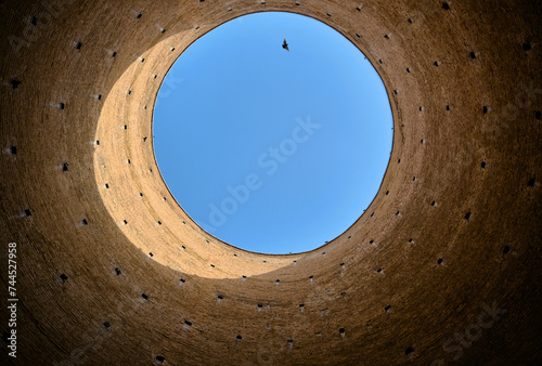 Inside the Toghrol Tower, Lown angle view Toghrol (Tughrul)  Tower with flying bird and blue sky photo