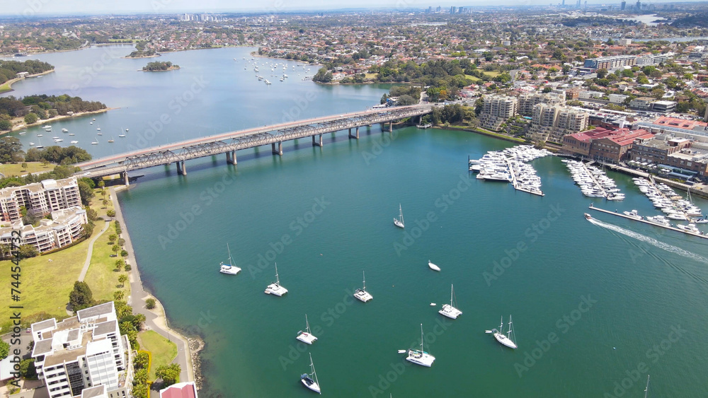 Aerial drone pullback reverse view over Balmain in Sydney, New South Wales, Australia looking toward Sommerville Point and Birkenhead Point on a sunny day    