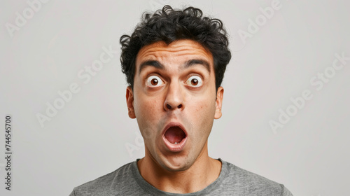 shocked man with wide eyes and an open mouth, giving an exaggerated expression of surprise or disbelief. photo