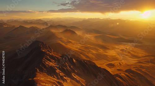 A breathtaking aerial view of a vast mountain range at sunrise.