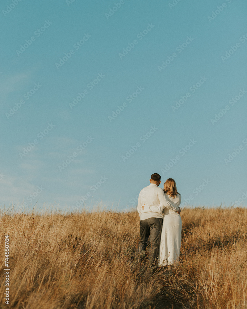 Couple standing on the top of the hill in the wheat meadow. Beautiful landscape of deep blue sky and wheat field. Couple hugs in the middle of nature. couple outdoors enjoying the fresh air
Couple standing on the top of the hill in the wheat meadow. Beautiful landscape of deep blue sky and wheat field. Couple hugs in the middle of nature. couple outdoors enjoying the fresh air