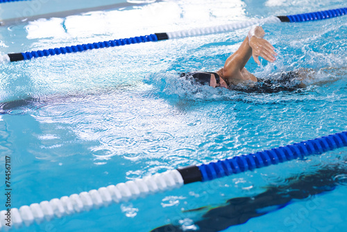 Caucasian female athlete swimmer swimming laps in a pool, with copy space