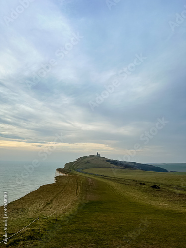 Eastbourne, England, UK. Belle Tout Lighthouse view from Seven Sisters cliffs in East Sussex. Cliff walking path view from Beachy Head to Birling Gap in Southern England.