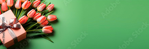 Mother's Day decorations concept Birthday 8 march Top view trendy gift box with ribbon bows pink tulips on isolated pastel green background Copyspace Empty space text advert Greeting card Wide format #744570111