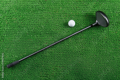Close-up of a golf ball and club on green grass