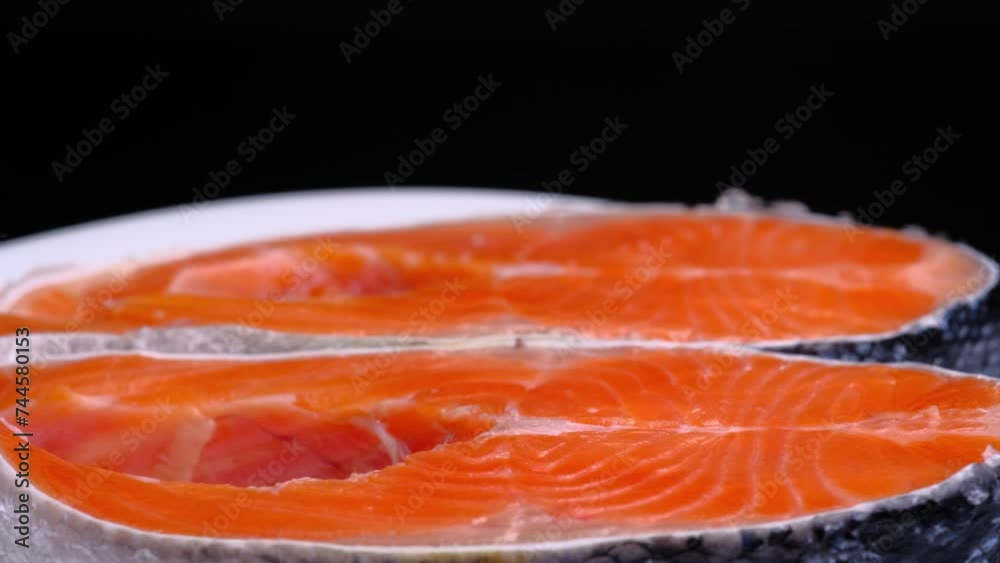 Raw salmon tenderloin on a white plate on a black background. Salmon. Seafood.Trout Steak Raw salmon tenderloin on a white plate on a black background. Salmon. Seafood.Trout Steak