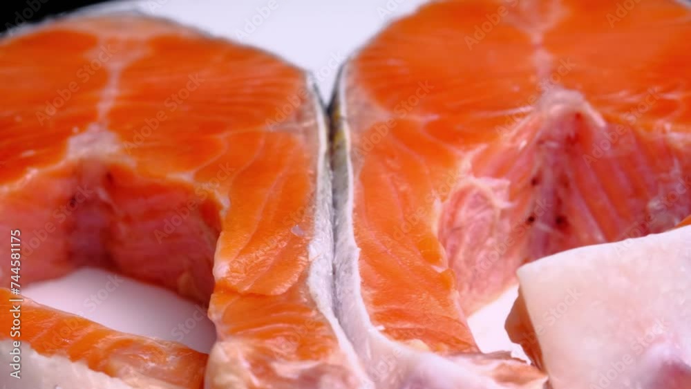 Two salmon steaks rotate slowly, on a white background, close-up. Salmon texture. Seafood.Trout Steak macro food video Two salmon steaks rotate slowly, on a white background, close-up. Salmon texture. Seafood.Trout Steak macro food video
