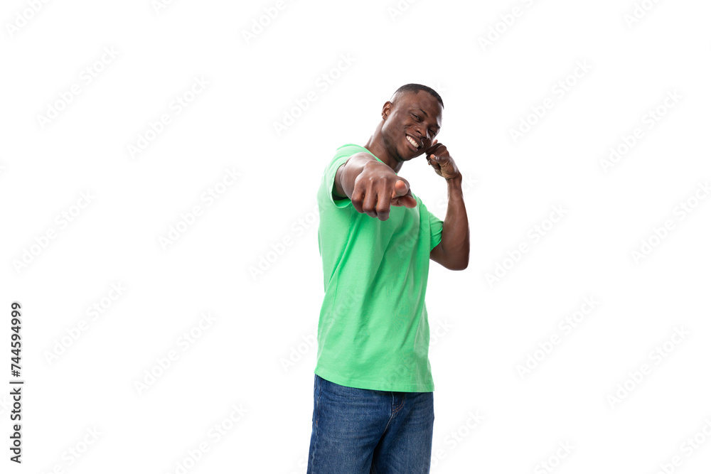 young stylish american man in casual t-shirt and jeans points with his hand on a white background young stylish american man in casual t-shirt and jeans points with his hand on a white background
