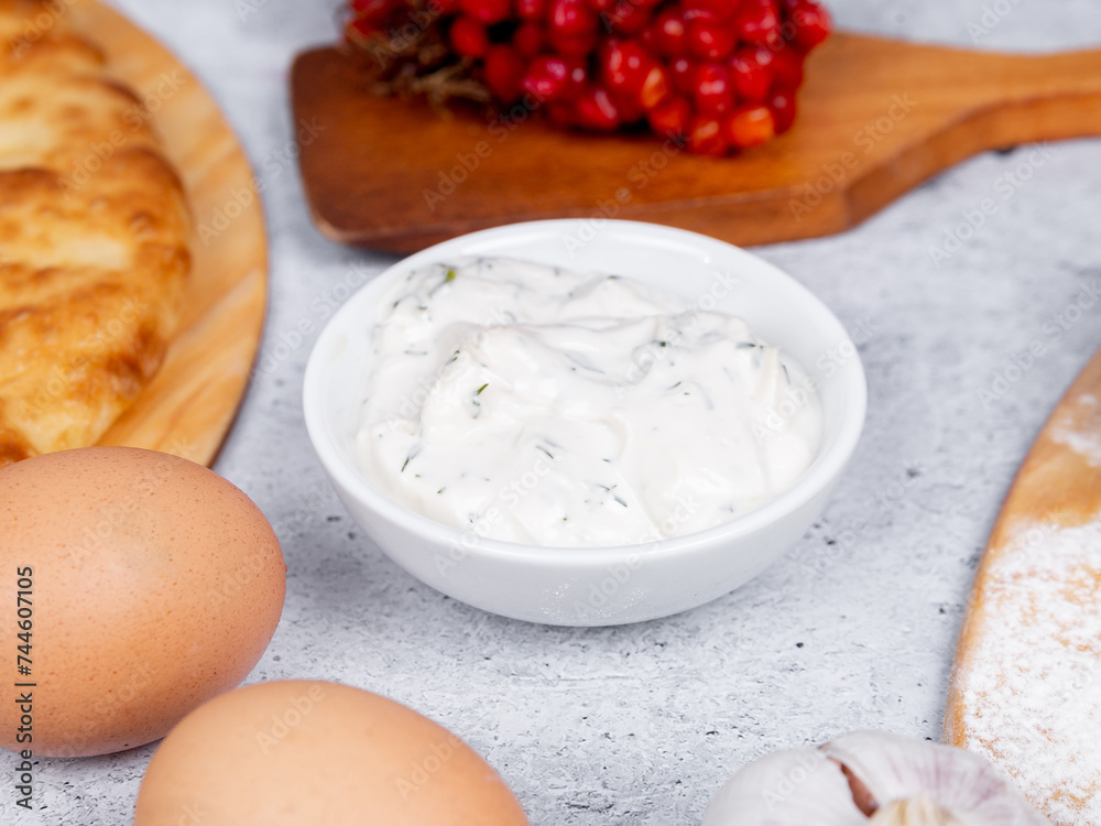 white sauce on a gray background in a beautiful white bowl