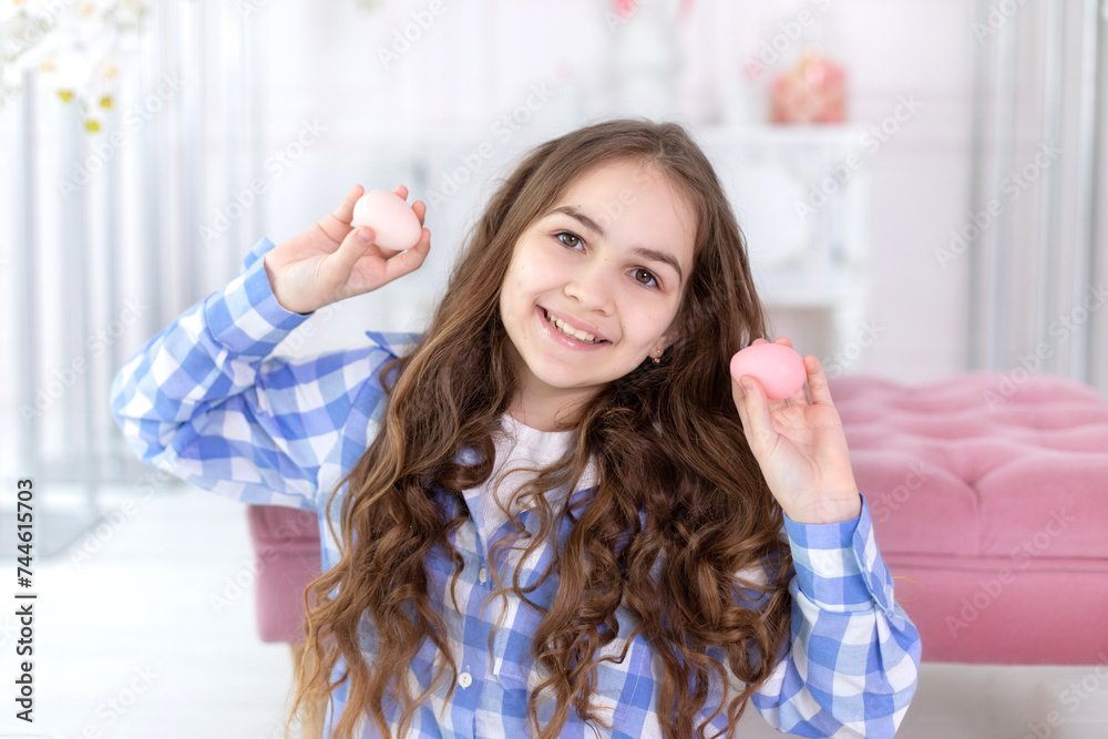 CloseUp portrait of happy little girl with easter eggs in hands at home. Girl and easter pink eggs. Child is preparing for Easter. Little Girl hunts and picks up easter eggs from table. CloseUp portrait of happy little girl with easter eggs in hands at home. Girl and easter pink eggs. Child is preparing for Easter. Little Girl hunts and picks up easter eggs from table.