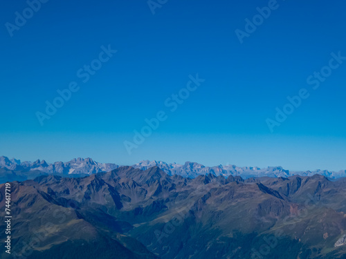 Panoramic view from majestic mountain peak of Hochschober, Schober Group, High Tauern National Park, East Tyrol, Austria. Wanderlust Austrian Alps in summer. Misty rugged ridges against clear blue sky photo