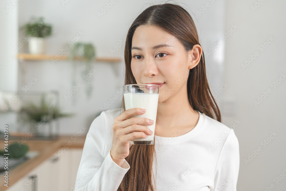 Health care, pretty asian young woman, girl drinking a glass of white fresh, dairy milk for calcium, vitamin wholesome good nutrition in morning at kitchen home. lifestyle, product healthy people. Health care, pretty asian young woman, girl drinking a glass of white fresh, dairy milk for calcium, vitamin wholesome good nutrition in morning at kitchen home. lifestyle, product healthy people.