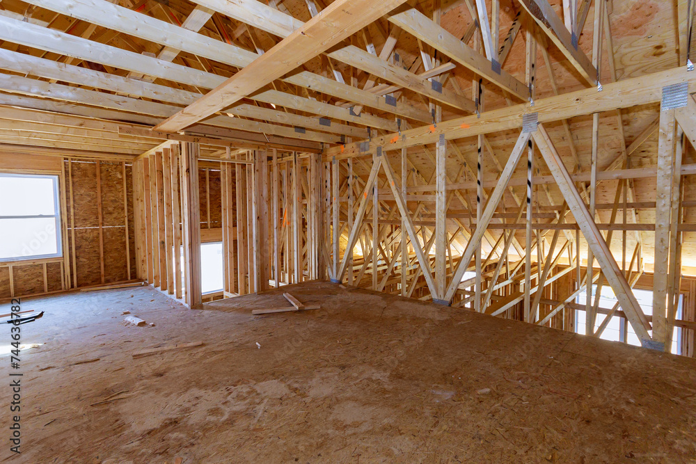 Construction work in progress an unfinished house with wooden framing beams view Construction work in progress an unfinished house with wooden framing beams view