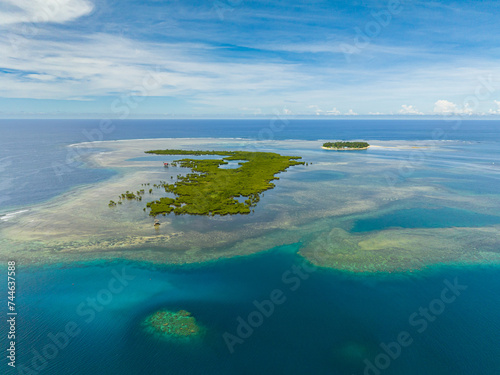 Drone view of tropical landscape with small island. Coral reefs in turquoise water. Mindanao, Philippines.