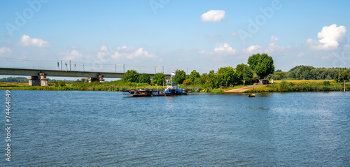 Foto Ferry and railbridge over the river Lek (Rhine) near Culemborg, Netherlands