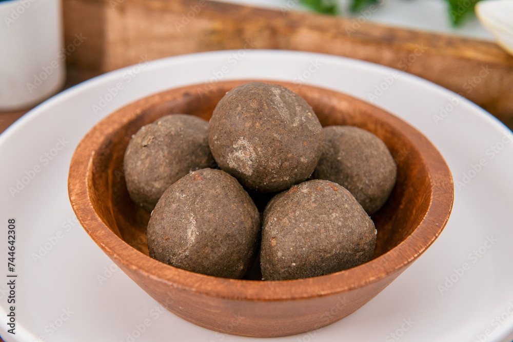 Fototapeta premium Fresh home made urad dal and millet laddu isolated and decorated. Locally called Urad Dal Ladoo, Ulundu urundan, Ulundu laddu, Kambu laddu. Selective focused millet ladoo.