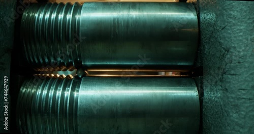 Jeweler rolling silver stick through rolling mill