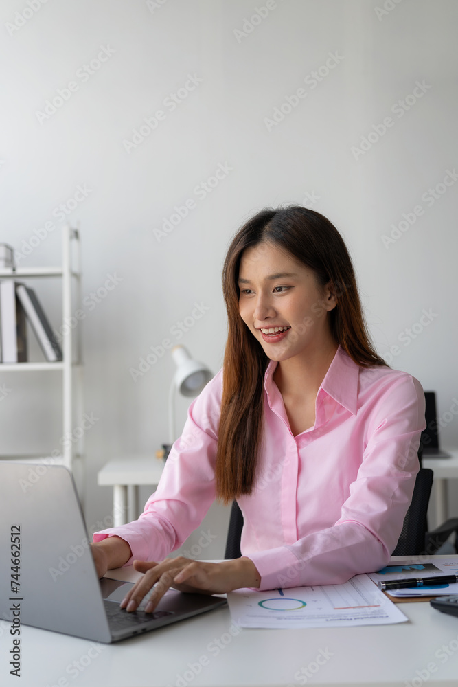 Annual summary report, laptop and paper placed at desk, Asian woman working online and planning financial data with laptop and succeeding with excited and happy face Annual summary report, laptop and paper placed at desk, Asian woman working online and planning financial data with laptop and succeeding with excited and happy face