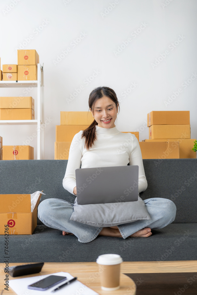 Starting a small business, SME business for online sellers independent asian girl Using the computer and taking orders to package products to deliver to customers. Delivery concept. Vertical image. Starting a small business, SME business for online sellers independent asian girl Using the computer and taking orders to package products to deliver to customers. Delivery concept. Vertical image.