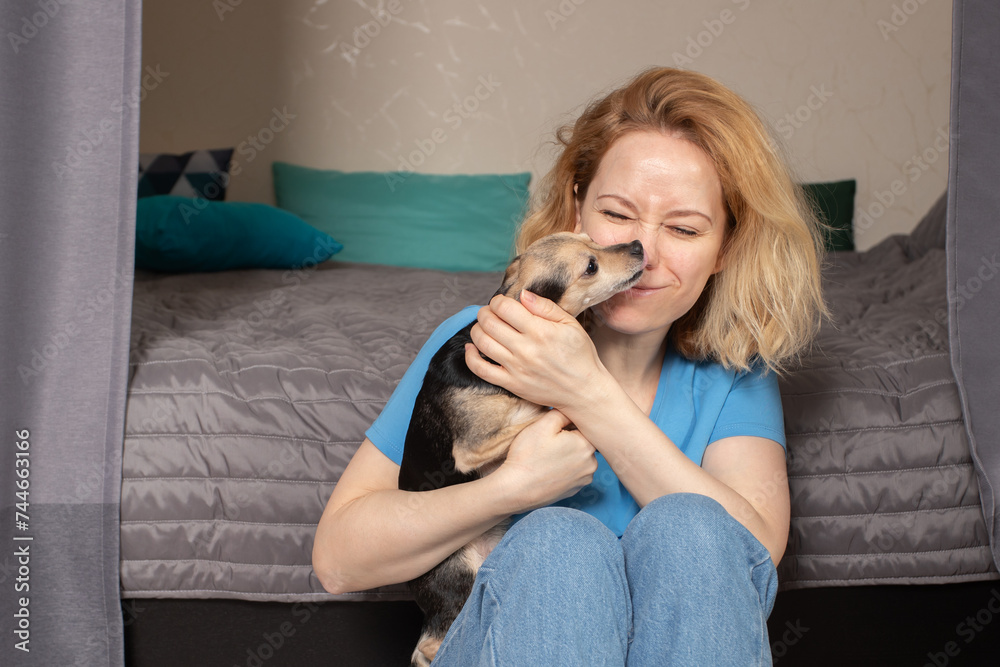 Happy woman with dog at home, petting and caressing, canine friendship
