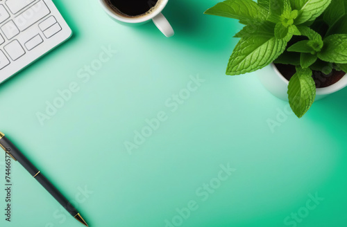 Elegant workspace with top view featuring a graceful arrangement. A coffee cup, empty notebook, pen, and a lush plant in a pot adorn the desk, creating a serene and atmosphere. Mint green color scheme