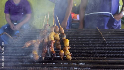 Roasted palm larvae on skewers. Street food in Ecuador, town of Puerto Francisco de Orellana, also known as El Coca. High quality FullHD footage