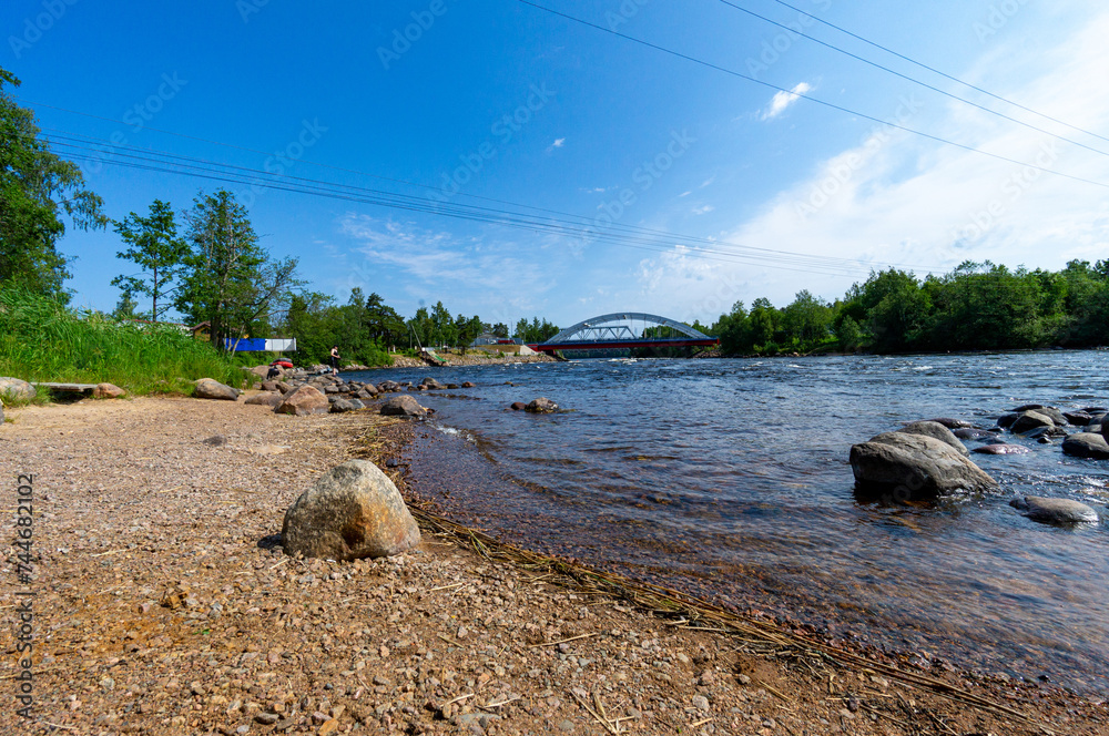 Fototapeta premium A fast river under a blue sky.