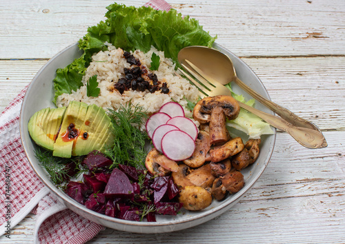 Vegan rice bowl, mushrooms, beets, avocado. Green plant based bowl. photo