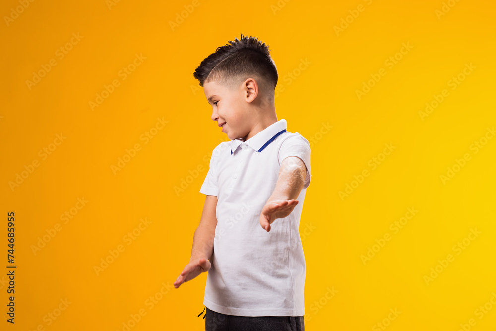 Child boy showing stop gesture on yellow background. Bulling and negative emotions concept Child boy showing stop gesture on yellow background. Bulling and negative emotions concept