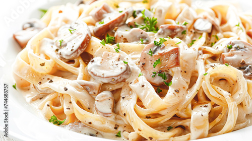 Creamy mushroom fettuccine alfredo topped with fresh herbs on a white dish.