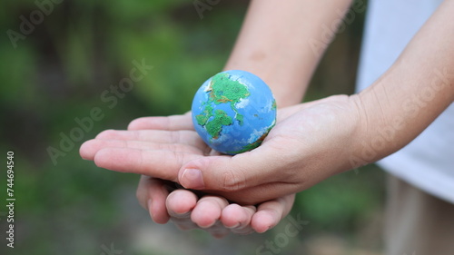Fototapeta Naklejka Na Ścianę i Meble -  Environment Earth Day In the hands holding green earth on Bokeh green Background, Saving environment, and environmentally sustainable. Save Earth. Concept of the Environment World Earth Day