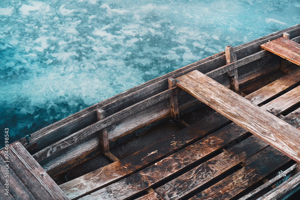 Close up of an old wooden rowboat on the frozen lake. Close up of an old wooden rowboat on the frozen lake.