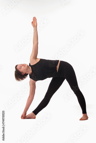 Triangle Pose Yoga (Utthita Trikonasana), Ashtanga yoga Side view of woman wearing sportswear doing Yoga exercise against white background.