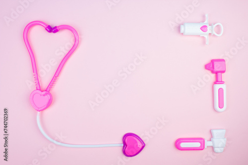The concept of a pediatrician. Pediatrics. Toy medical devices on a pink background. Children play professional doctor. Choice of profession. Get vaccinated. © lana_u