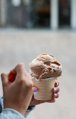 Hand of a girl or teenager holding an ice cream.