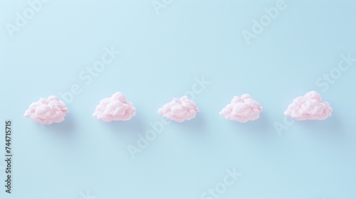 a row of pink cotton balls sitting on top of a blue table next to each other on a light blue surface.