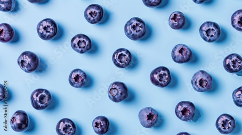 a group of blueberries sitting next to each other on a blue surface with holes in the middle of them.