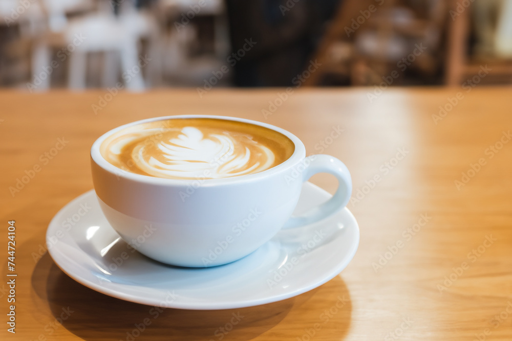 Obraz premium Hot coffee latte in cup mug on the table in cafe