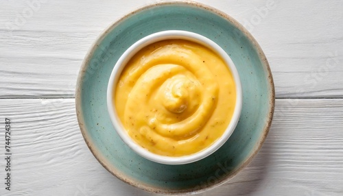 top view on a cup of cheese sauce on white background