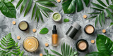 different cosmetics and make up products with tropical leaves on a gray marble 