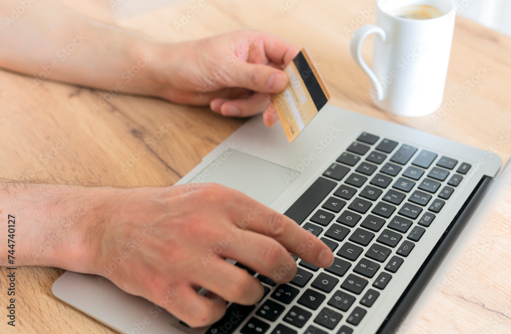 Hand with credit card and with laptop computer. Online shopping concept Hand with credit card and with laptop computer. Online shopping concept