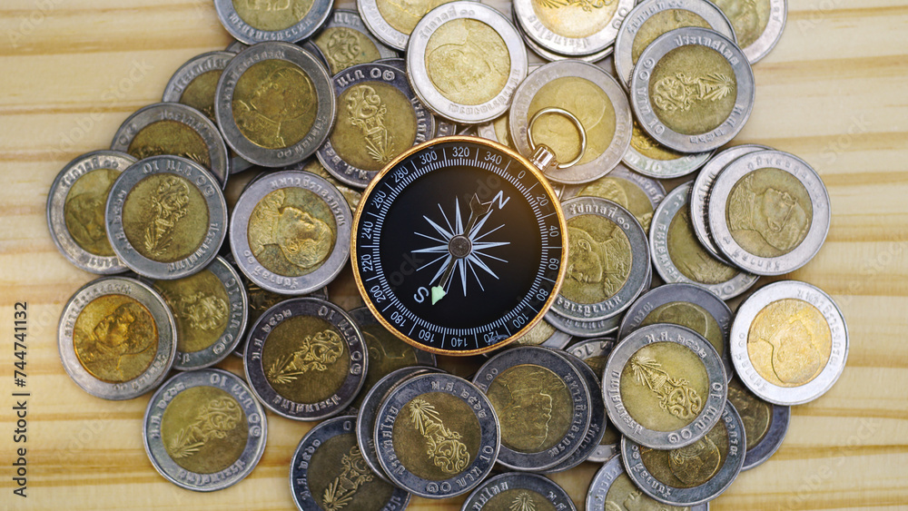 Compass and coins on wooden table background, navigation on money, guideline finance concept. Business Money Learning. Money coach.Travel saving. Cash Back from travelling. Top view. Compass and coins on wooden table background, navigation on money, guideline finance concept. Business Money Learning. Money coach.Travel saving. Cash Back from travelling. Top view.