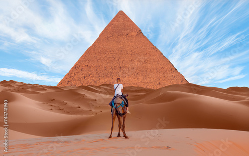 Camels in Giza Pyramid Complex - A woman riding a camel across the thin sand dunes - Cairo  Egypt