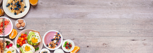 Healthy breakfast or brunch corner border on a wood banner background. Top down view. Avocado toast, smoothie bowls, oats, yogurt and assorted nutritious foods.