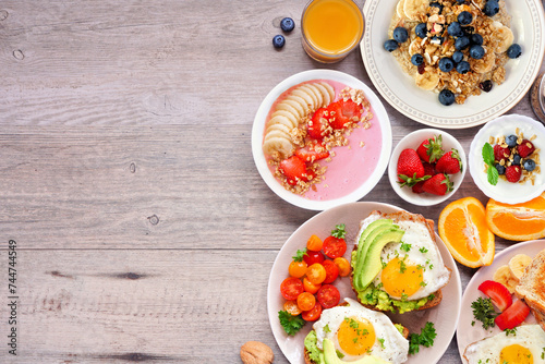 Healthy breakfast or brunch side border on a wood background. Top view. Avocado toast, smoothie bowls, oats, yogurt and a collection of nutritious foods.