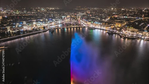 Wallpaper Mural Aerial hyper lapse shot of night city. Backwards fly above river surrounded by illuminated streets and buildings. Revealing Geneve lake with Jet d Eau water fountain. Geneva, Switzerland Torontodigital.ca