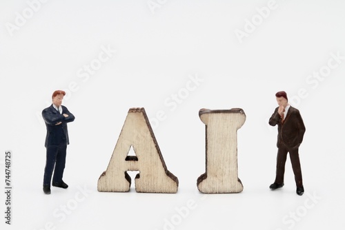 miniature figurines of businessmen with artificial intelligence abbreviation