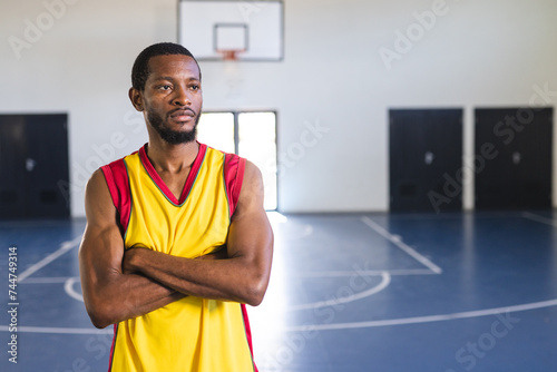 African American man stands confidently on a basketball court photo