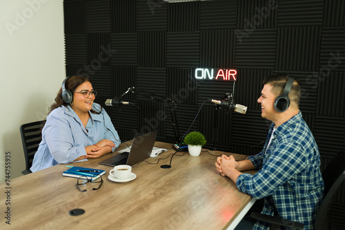 Foto Hispanic woman with a guest recording a podcat episode in the studio