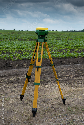 leveler tripod GPS equipment mounted on tripod in green organic field. GPS, GIS equipment.